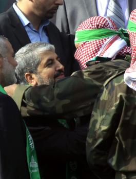 A-Palestinian-member-of-the-Ezzedine-al-Qassam-brigades-hugs-Hamas-chief-Khaled-Meshaal-as-Hamas-prime-minister-Ismail-Haniya-looks