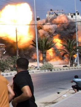 Palestinian-men-look-on-as-a-bomb-from-an-Israeli-air-strike-hits-a-house-in-Gaza-City