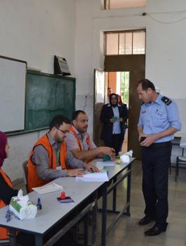 أحد رجال الأمن يدخل قاعة الاقتراع