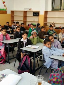 معلمة وطالباتها يألفن كتاب باللغة الانجليزية بعنوان "ما قالته جدتي"