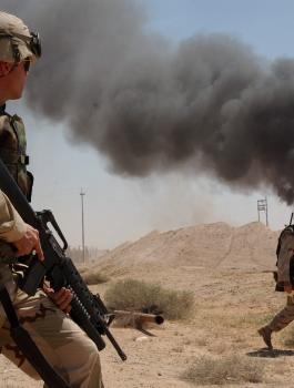 US_Navy_030402-N-5362A-004_U.S._Army_Sgt._Mark_Phiffer_stands_guard_duty_near_a_burning_oil_well_in_the_Rumaylah_Oil_Fields_in_Southern_Iraq
