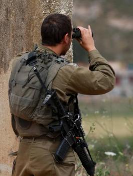 An Israeli soldier positioned near the northern town of Metula monitors the fence with Lebanon, 21 May 2022 (AFP).jpg