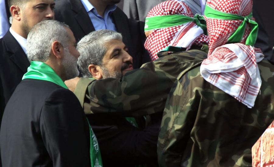 A-Palestinian-member-of-the-Ezzedine-al-Qassam-brigades-hugs-Hamas-chief-Khaled-Meshaal-as-Hamas-prime-minister-Ismail-Haniya-looks