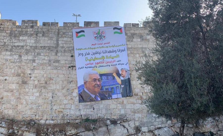 ازالة لافتة تحمل صور الرئيس في القدس 