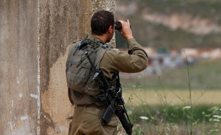 An Israeli soldier positioned near the northern town of Metula monitors the fence with Lebanon, 21 May 2022 (AFP).jpg