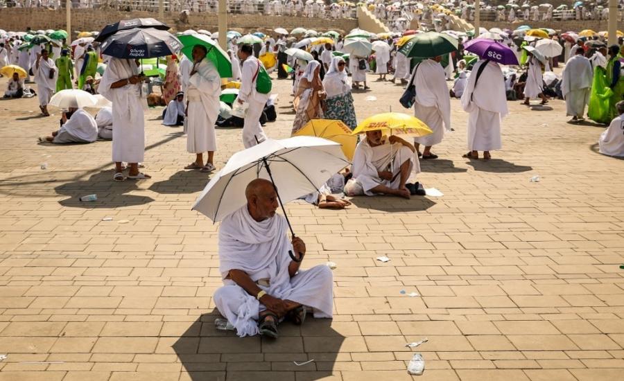 Muslim pilgrims use umbrellas to shade themselves from the sun as they arrive at the base of Mount Arafat, also known as Jabal al-Rahma or Mount of Mercy, during the annual hajj pilgrimage on June 15, 2024 Fadel SENNA _.jpg